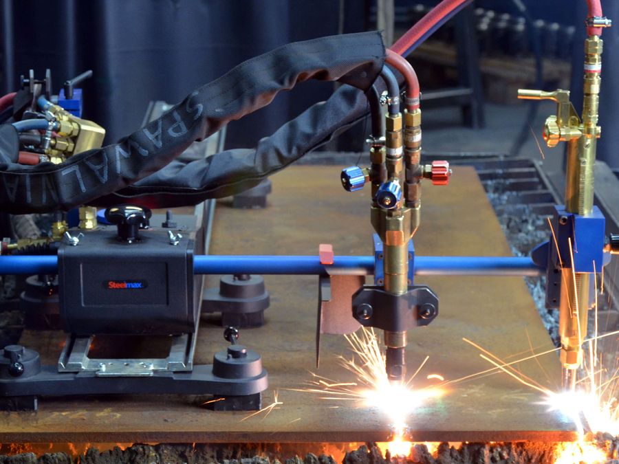 Oxy-fuel torch flame cutting thick steel plate with sparks